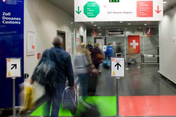 Reisende gehen durch rot / grün Durchgang am Flughafen