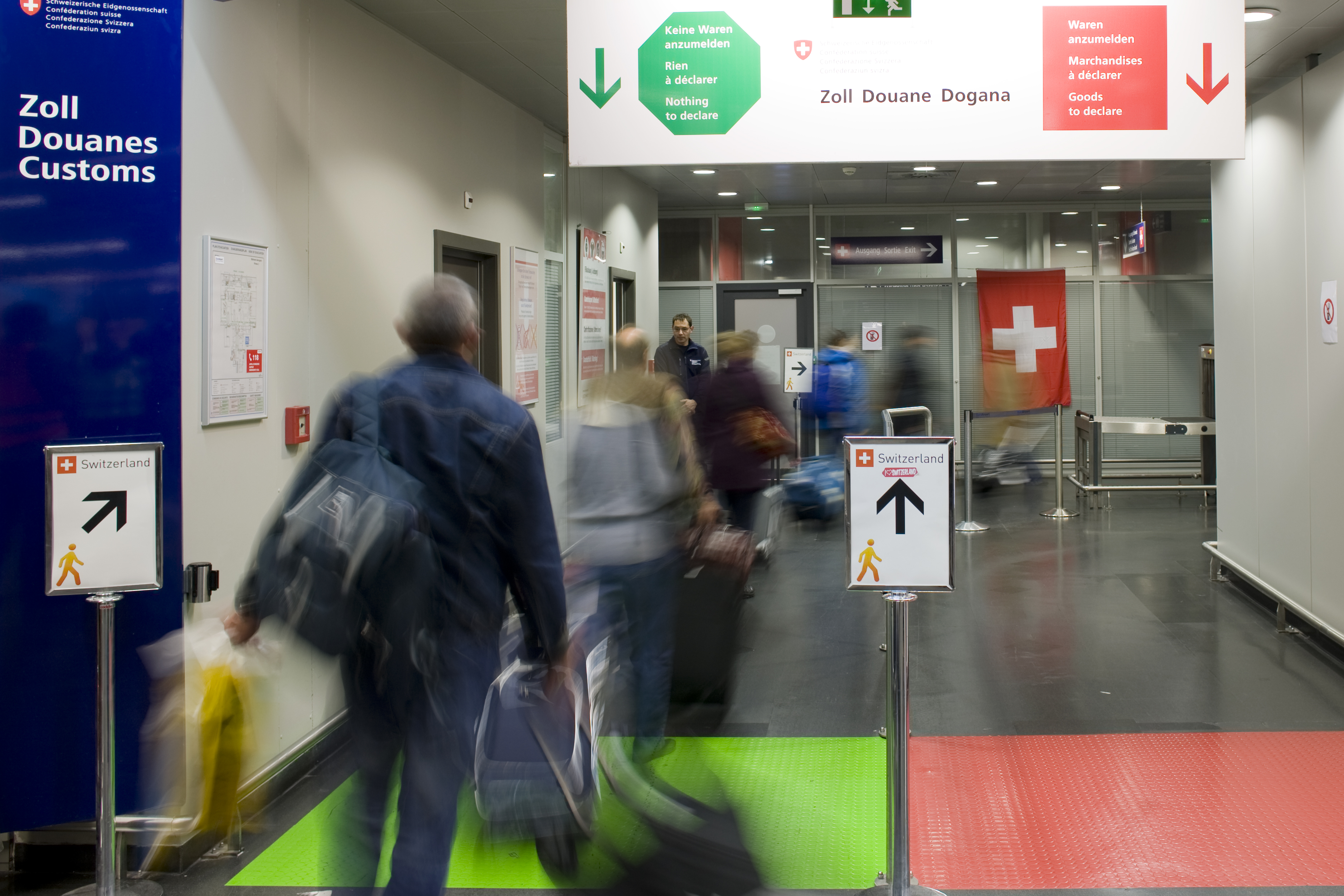 I viaggiatori passano attraverso il passaggio rosso / verde in aeroporto